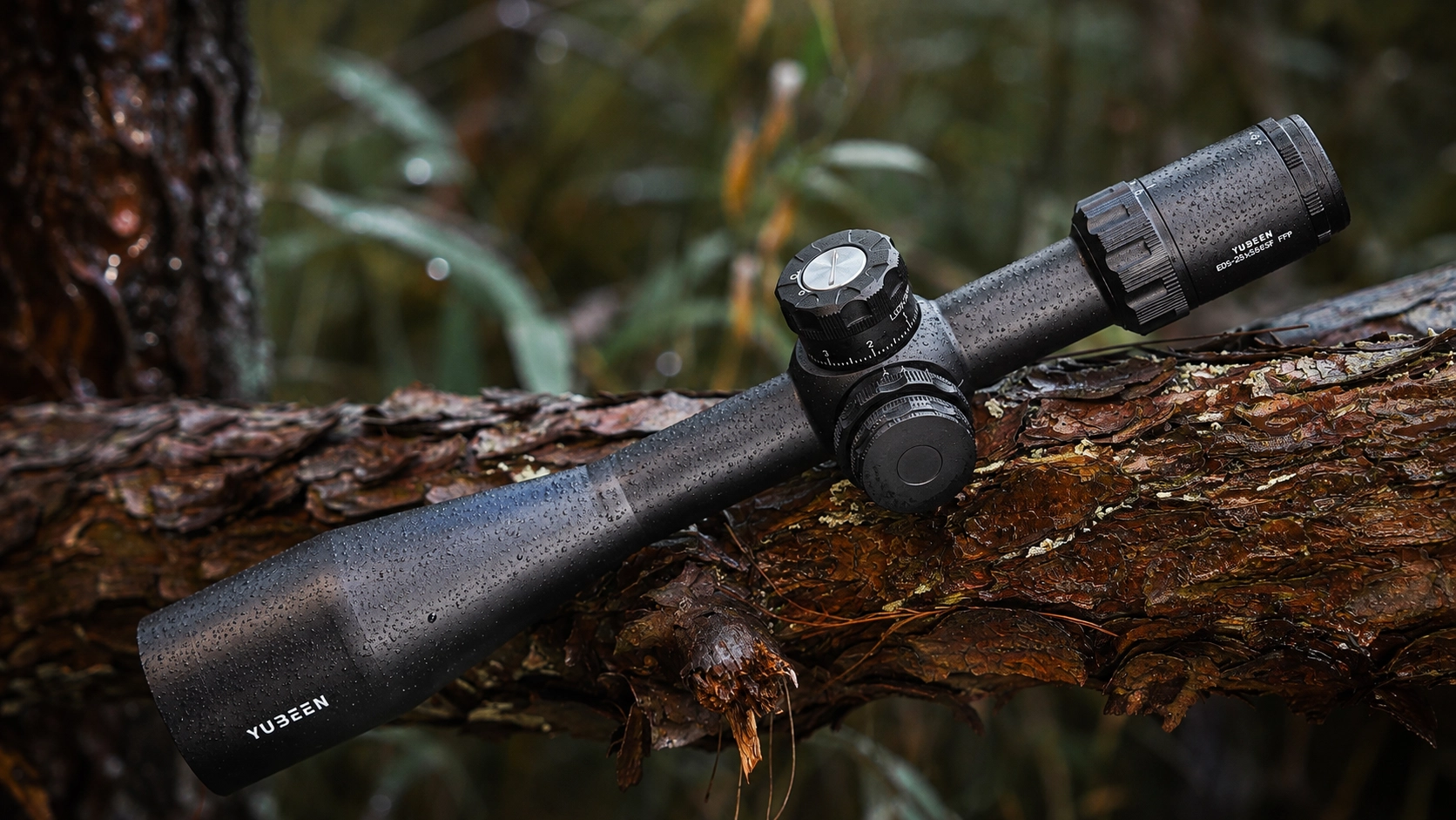 Yubeen ED5-25×56 SFIR FFP riflescope covered with rain droplets in woodland